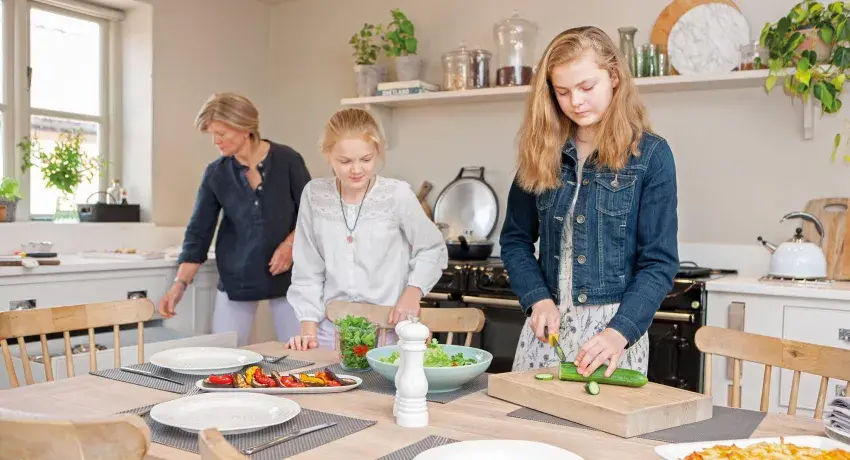 Family gathered around dining table infront of an AGA eR3 in Pewter