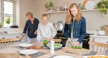 Family gathered around dining table infront of an AGA eR3 in Pewter