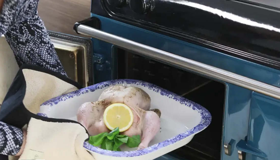 A chicken being placed in to the AGA oven