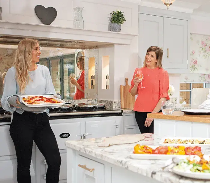 Friends gathered around an AGA cooker